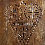 Ornament w kształcie serca wyrzeźbiony w drewnie.