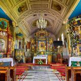 Wnętrze barokowego kościoła z bogato zdobionymi ołtarzami.