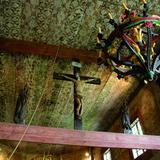 Sufit malowany w szlaczki w Kościele św. Leonarda w Lipnicy Murowanej. Na grubej drewnianej belce stoi krzyż z ukrzyżowanym Jezusem a po bokach figury Matki Bożej i Jana apostoła. Widać również zawieszony duży, metalowy żyrandol na świeczki, ozdobiony kolorowymi wstawkami.