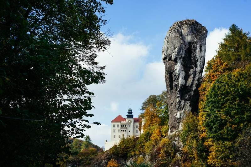 bujne drzewa po dwóch stronach, w środkowej części zamek z charakterystyczną skałą w kształcie maczugi, Pieskowa Skała