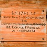 Drewniana tablica z napisem muzeum na ścianie.
