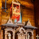 Drewniany główny ołtarz w formie frontowej ściany chaty góralskiej z płaskorzeźbą Serca Pana Jezusa w Kaplicy Najświętszego Serca Pana Jezusa w Jaszczurówce. Obok tabernakulum drewniane figury świętych.
