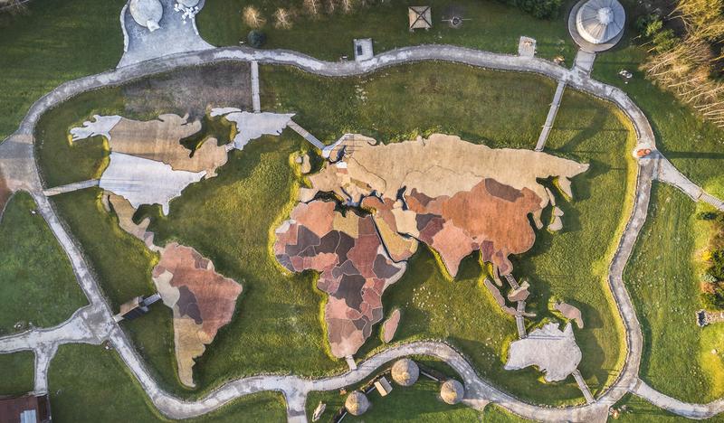 Zdjęcie dronowe przedstawia mapę świata z odwzorowanymi kontynentami Ziemi z oznaczonymi różnymi kolorami państwami.