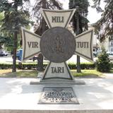 Zdjęcie przedstawia Grób Nieznanego Żołnierza zlokalizowanego na Placu Tadeusza Kościuszki w Oświęcimiu. Na pierwszym planie kamienny krzyż Virtuti Militari, z orłem i płyta z napisem.