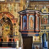 Wnętrze drewnianej cerkwi z z malowanymi ścianami, amboną podwieszoną z namalowanymi wizerunkami świętych. Pod nią zabudowane schody. Obok ikonostas z obrazami świętych ze złoceniami na około, z wąskim wejściem z łukiem w głąb prezbiterium. Po lewej ołtarz z małym obrazem zdobiony na około złoceniami, z filarami  i daszkiem na górze.