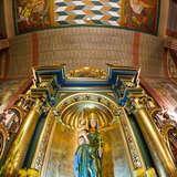Bogato polichromowane wnętrze kościoła, w niszy malowana figura Madonny z Dzieciątkiem.