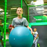 Chłopiec trzymający dużą piłkę gimnastyczną.