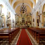 Nawa główna barokowego kościoła, widoczny ołtarz główny, ołtarze boczne i sklepienie kolebkowe z lunetami