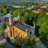 Widok z lotu ptaka na kościół rzymskokatolicki pw. św. Marcina z Tours w Krzeszowicach. Bryła kościoła jest na planie krzyża. Na dwie wieże. Za kościołem park.