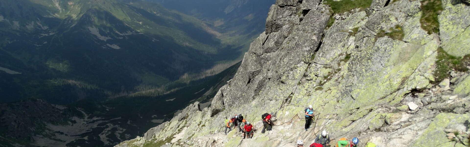 widok na grupę osób wspinających się po ścianie skalnej w drodze na szczyt Świnica w Tatrach