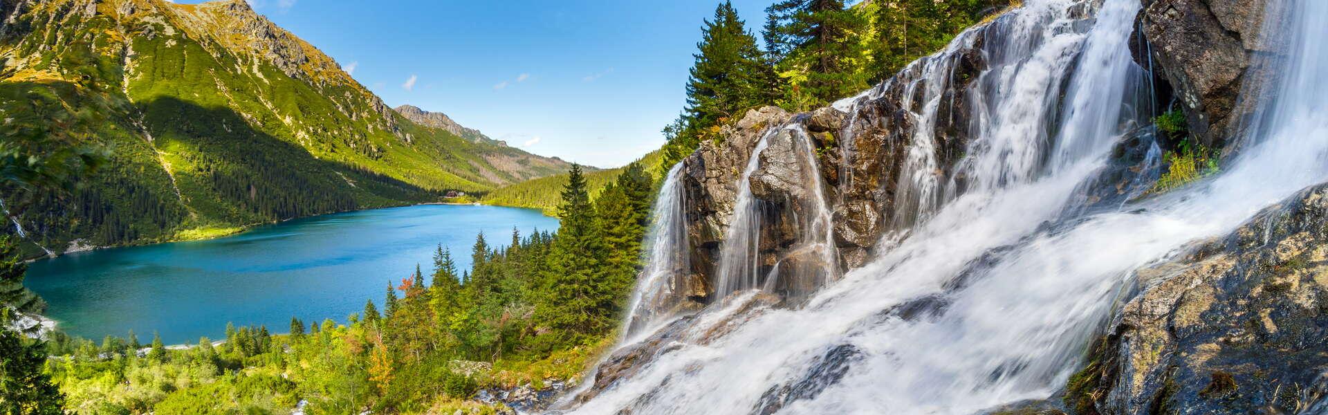 A waterfall and a lake among high mountains