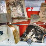 Eksponaty takie jak czasopisma czy dzienniki w szklanej gablocie Muzeum Niepodległości w Myślenicach.