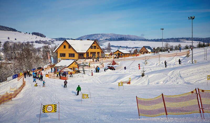 Widok na stację narciarską Master- Ski w Tyliczu, w tle wyciąg talerzykowy i tor saneczkowy