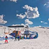 Grupa osób korzystających z usług stacji narciarskiej Master Ski w Tyliczu w zimowy słoneczny dzień