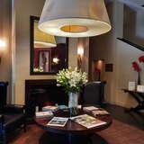 Elegancki okrąfły stół i dwa skórzane fotele w hotelu Modrzewie Park Szczawnica