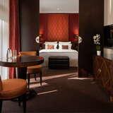 Elegancki pokój w hotelu Modrzewie Park Szczawnica z małżeńskim łożem, stolikiem, krzesłami i telewizorem