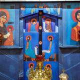 Niebieskie malunki ze świetymi na drewnie w Cerkwii Zaśnięcia NMP w Krakowie. Na pierwszym planie tuż przed tym znajduje się prawosławny świecznik.