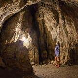 Widok na wnętrze Jaskini Wierzchowskiej Górnej. Pośrodku kobieta spoglądająca na skały..