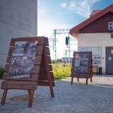 Wystawa przed budynkiem, na drewnianych stojakach są plansze z informacjami i ilustracjami o historii obiektu.
