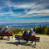 Widok z Jaworzyny Krynickiej na otoczenie, turyści siedzący na ławeczkach