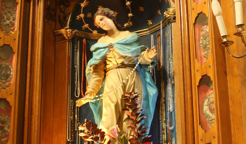 Figura Madonny w drewnianym ołtarzu.