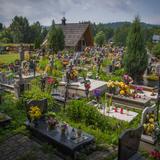 Cmentarz z nagrobkami, za nimi kaplica.