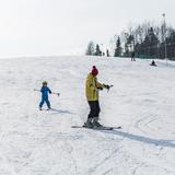 Nauka jazdy na nartach, dziecko jadące za instruktorem.