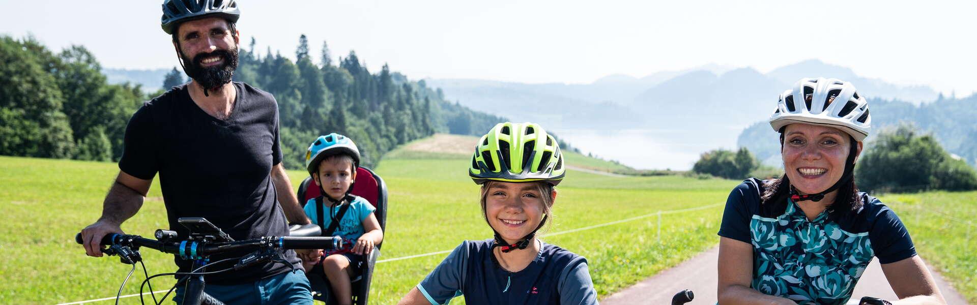 Czteroosobowa uśmiechnięta rodzina na wycieczce rowerowej